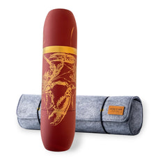 The Caskata X High Camp Flasks Red Lobster Flask stands upright in front of its gray felt carrying case with a brown label, showcasing its red stainless steel build and gold lobster design.