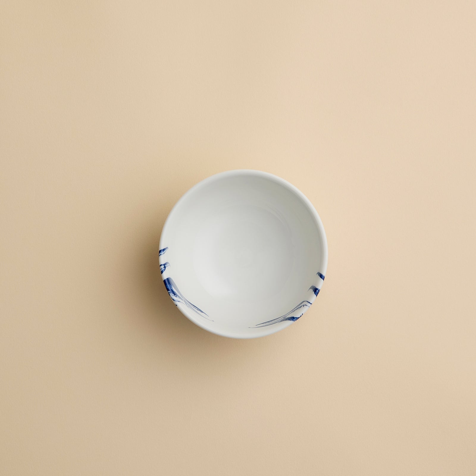 The Caskata Artisanal Home Crab Snack Bowl is a small coastal bowl featuring a blue crab design on the front, displayed against a simple beige background.