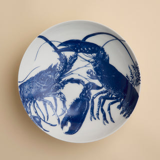 The Lobster Entrée Bowl by Caskata, from our coastal dinnerware collection, is a white ceramic bowl featuring a blue illustration of two lobsters facing each other on a beige background.