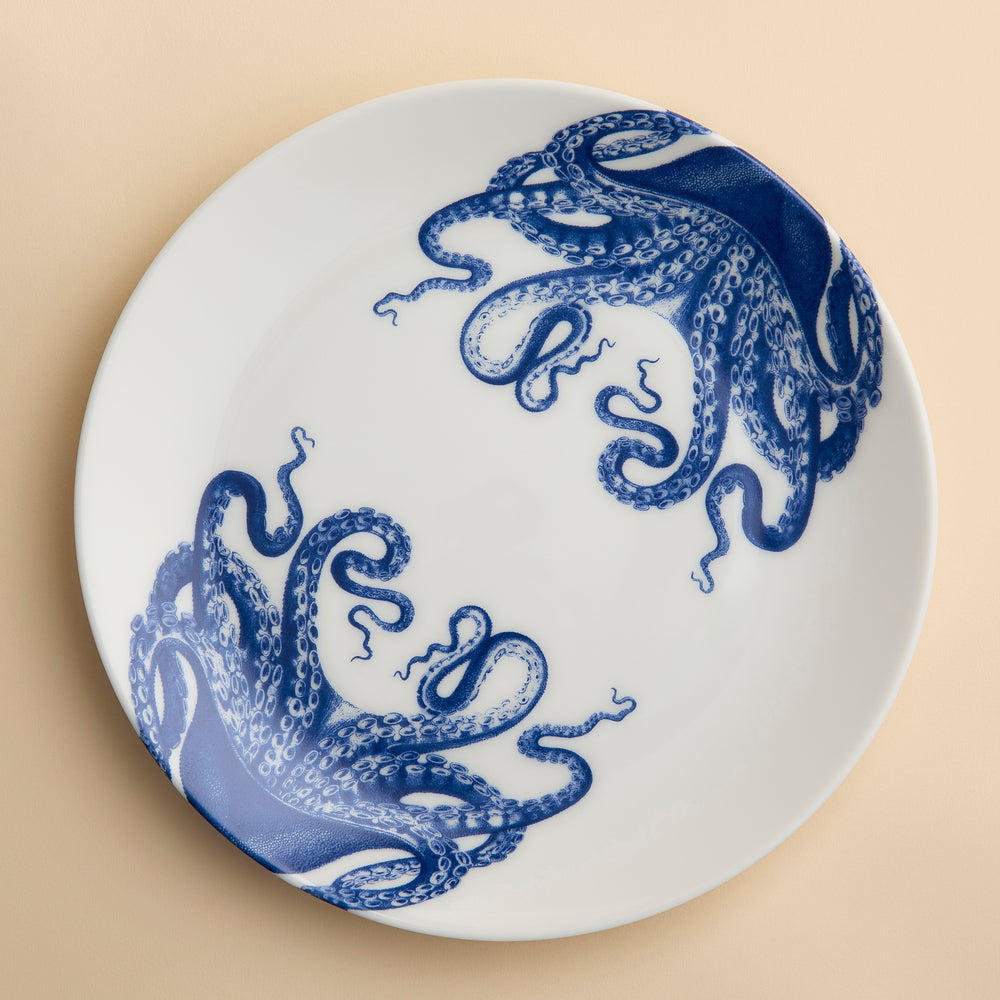 Lucy the Octopus wraps her blue tentacles around the rims of this coupe porcelain dinner plate from Caskata.