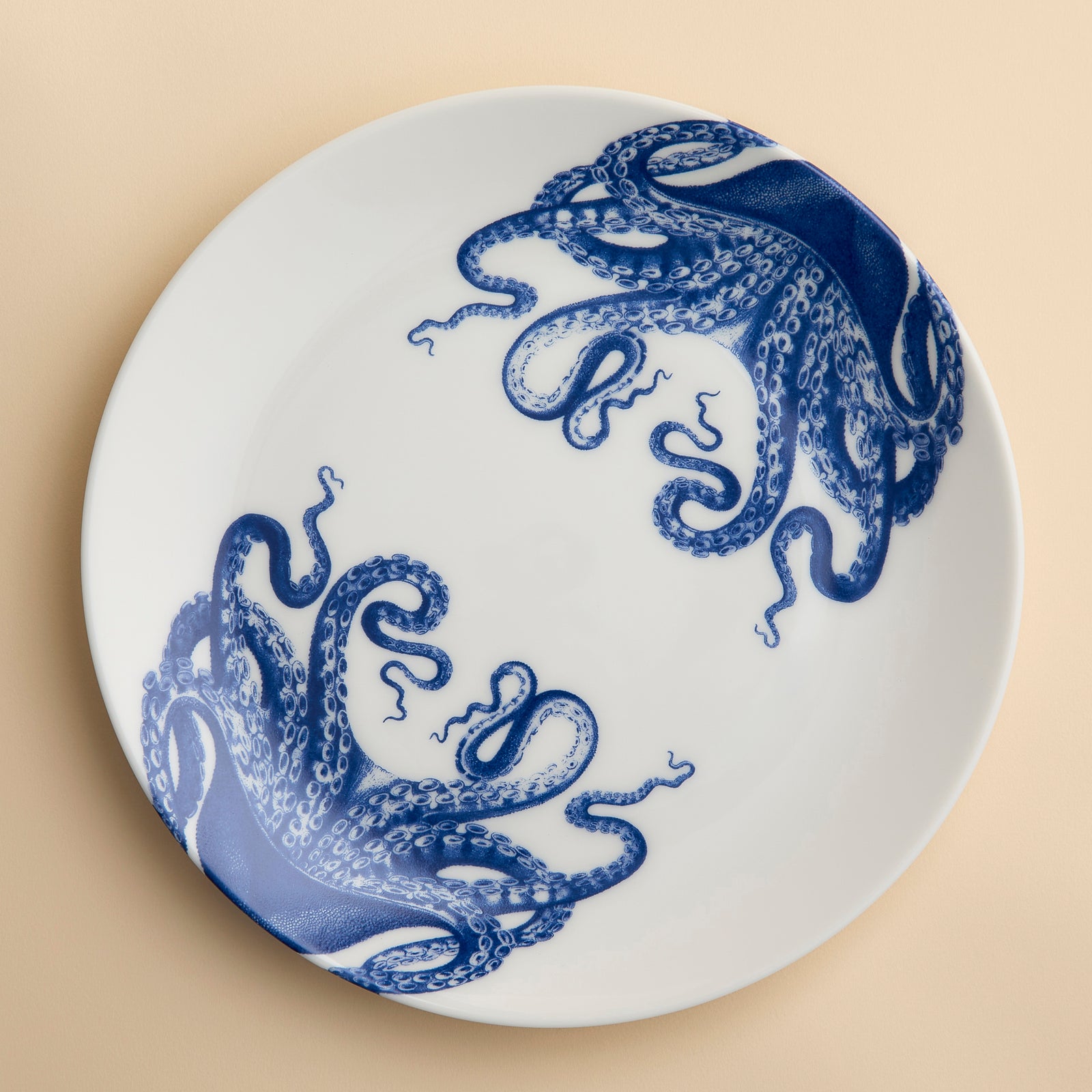 Lucy the Octopus wraps her blue tentacles around the rims of this coupe porcelain dinner plate from Caskata.