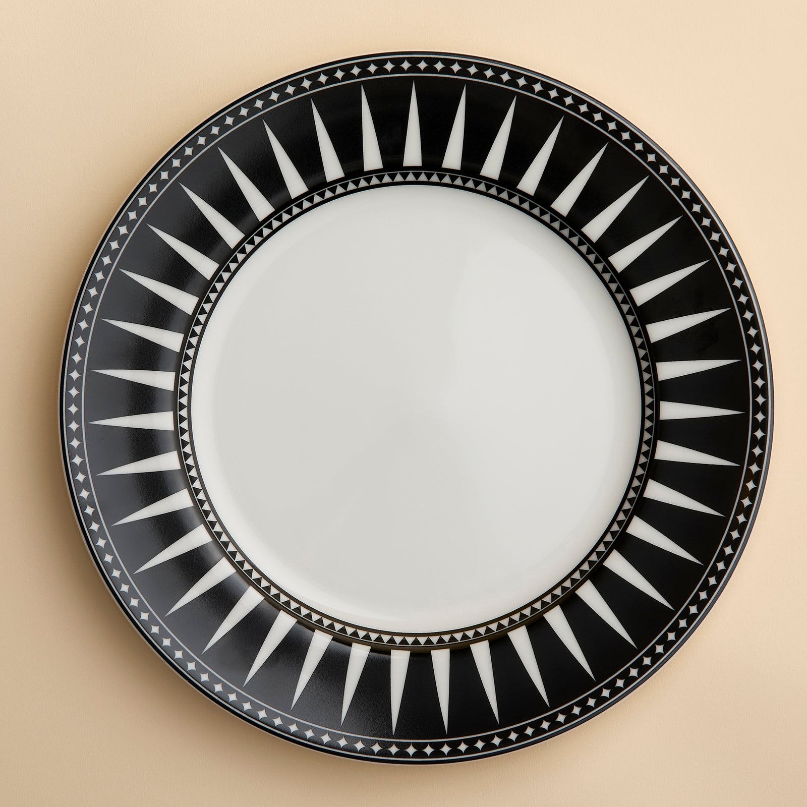 Marrakech pattern porcelain dinner plate from Caskata showcases bold black and white geometric spike designs around the rim making a perfect frame for good food.