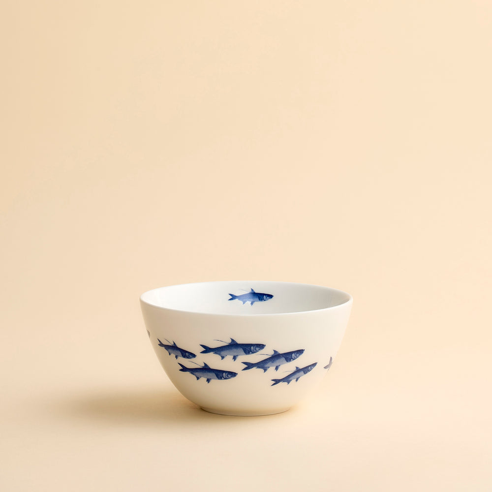 An adorable cereal bowl in high-fired porcelain features a bright blue School of Fish swimming around and inside this hand-decorated porcelain cereal bowl from Caskata.