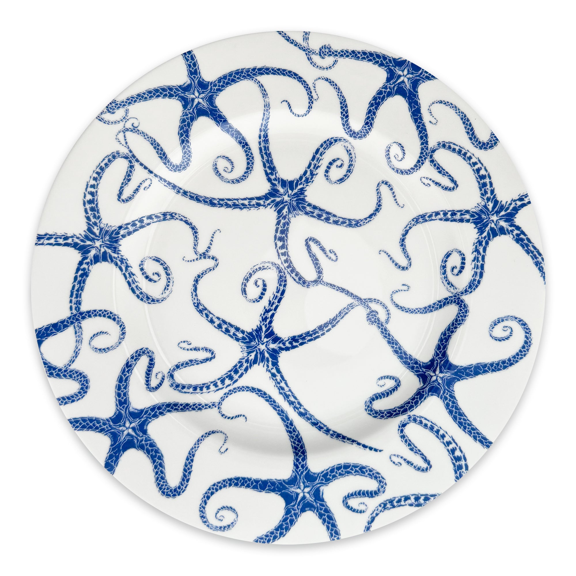A limited-edition white Starfish Rimmed Dinner Plate from Caskata Artisanal Home features a decorative pattern of blue octopuses intertwined with their tentacles, creating a captivating design.