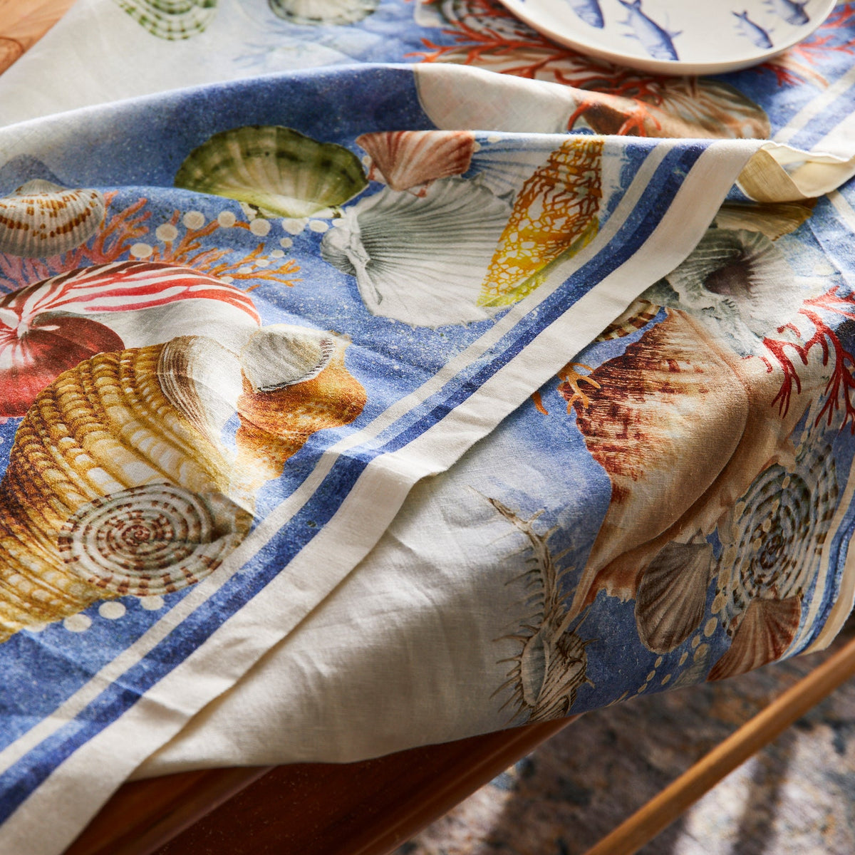 A Sanibel Linen tablecloth adorned with sea shells.