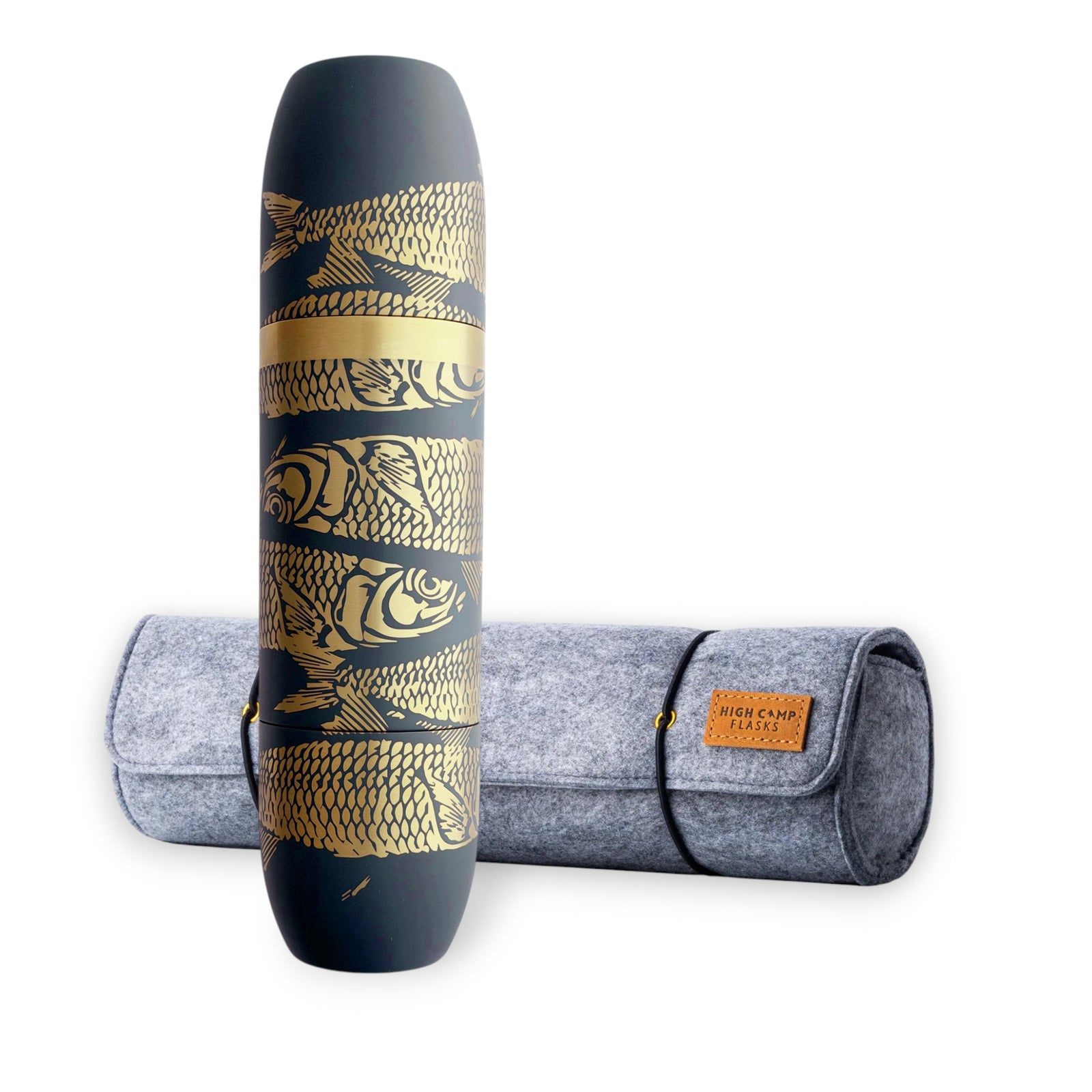 The Caskata x High Camp Dark Blue Sardines Parkside Flask features gold fish and scale designs and comes with a gray felt carrying case, blending coastal-inspired style with the convenience of magnetized cups.