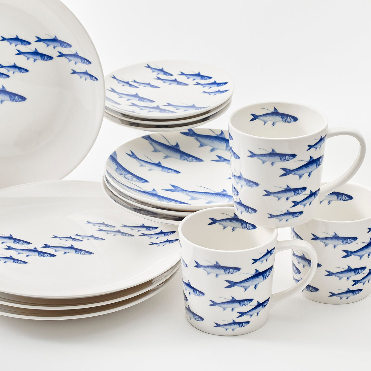A set of Caskata porcelain dinnerware with sharks on it, perfect for your School of Fish Table for 4.