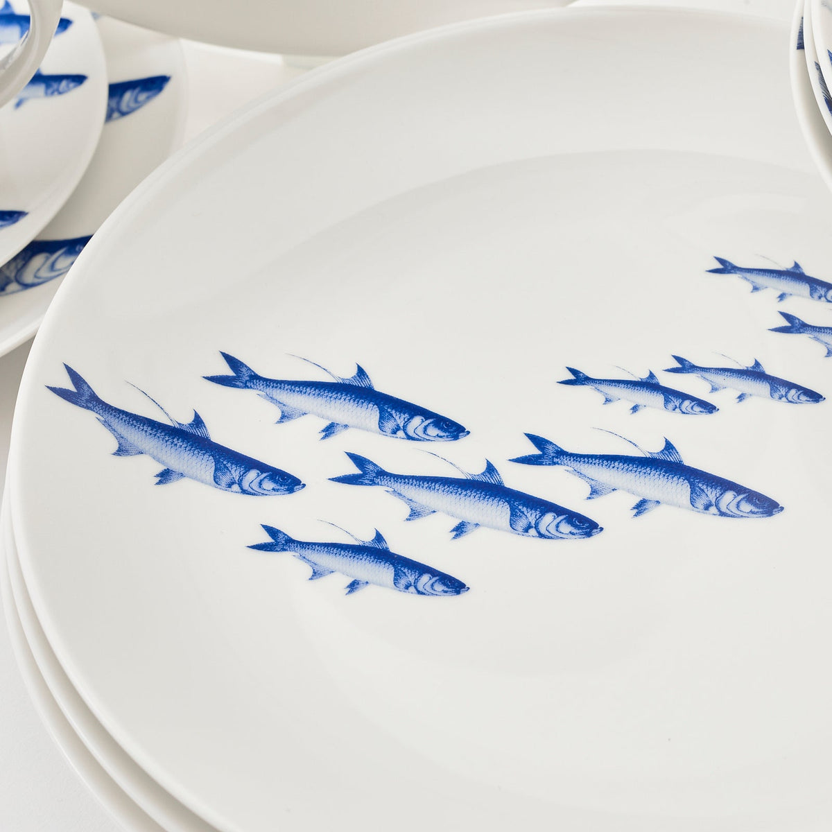 A 16 piece set of blue and white plates with fish on them, the School of Fish Table for 4 by Caskata.
