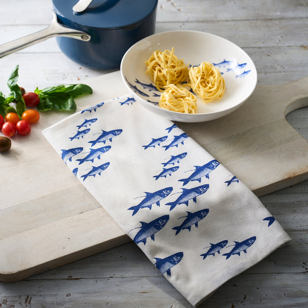 A School of Fish Kitchen Towels Set/2 from Caskata, featuring a school of blue and white fish, adds a touch of seafaring whimsy to your kitchen.