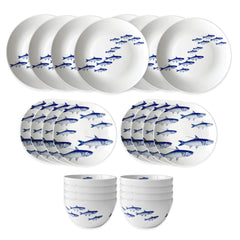 The Caskata School of Fish Table for 8 is a 24-piece porcelain dinnerware set featuring white plates and bowls with blue fish designs. Dishwasher and microwave safe, it’s shown neatly arranged on a white background.