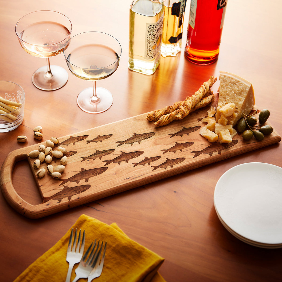 A Caskata School of Fish Serving Board crafted from cherry wood, featuring a delightful fish motif.