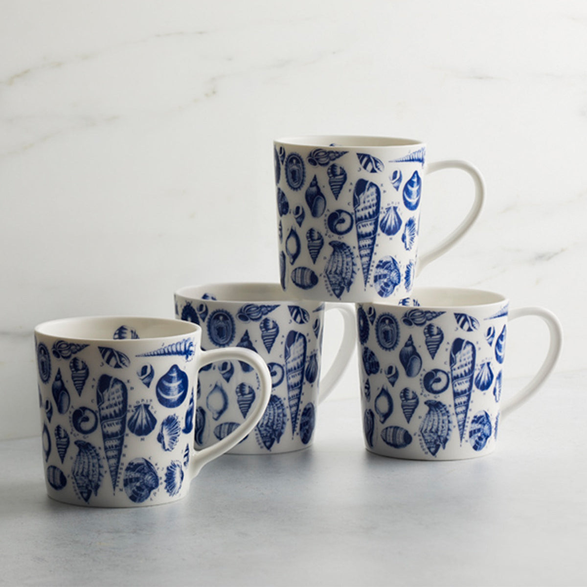 Four Mixed Shells Mugs Blue by Caskata Artisanal Home with blue and white designs on them.