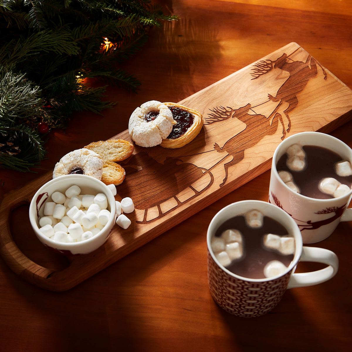 A Santa&#39;s Sleigh Serving Board adorned with holiday whimsy, featuring a delightful spread of hot cocoa and marshmallows, by Caskata.