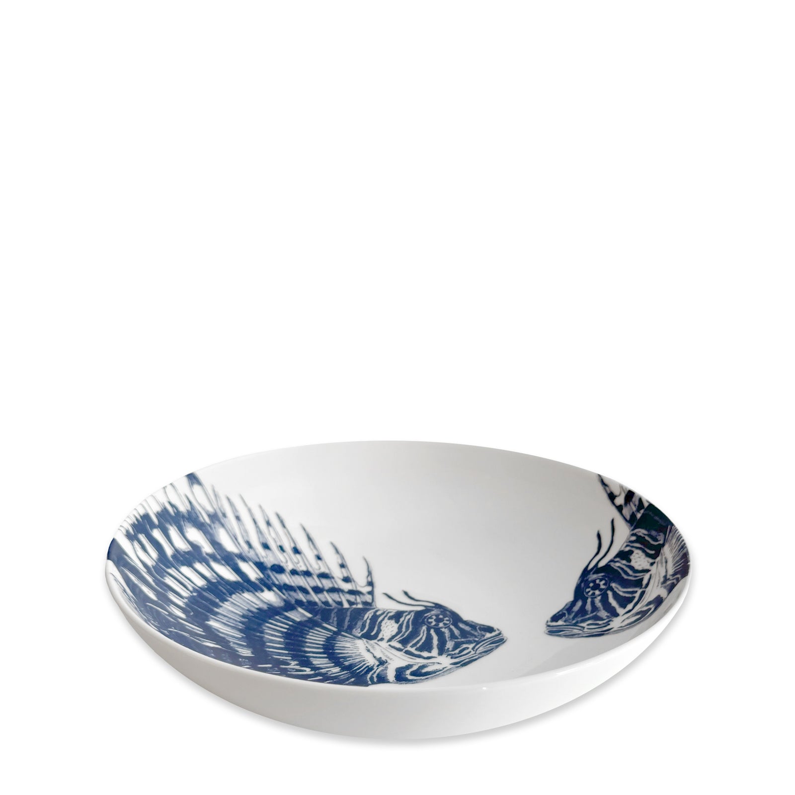 The Caskata Spiky Fish Entrée Bowl is a white shallow bowl with two blue fish illustrations inside, perfect coastal dinnerware for adding a fresh maritime touch.