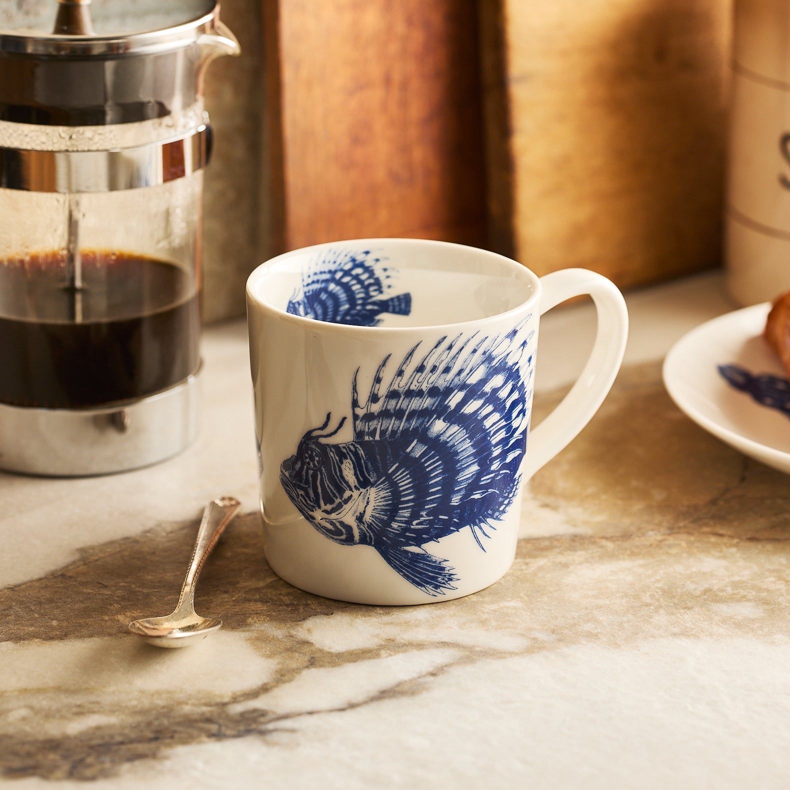 The Ella in the Morning Bundle by Caskata features a spiky fish mug with blue fish design, soap, ribbon, gift tag, and polka dot wrapping—an ideal beach lover gift.