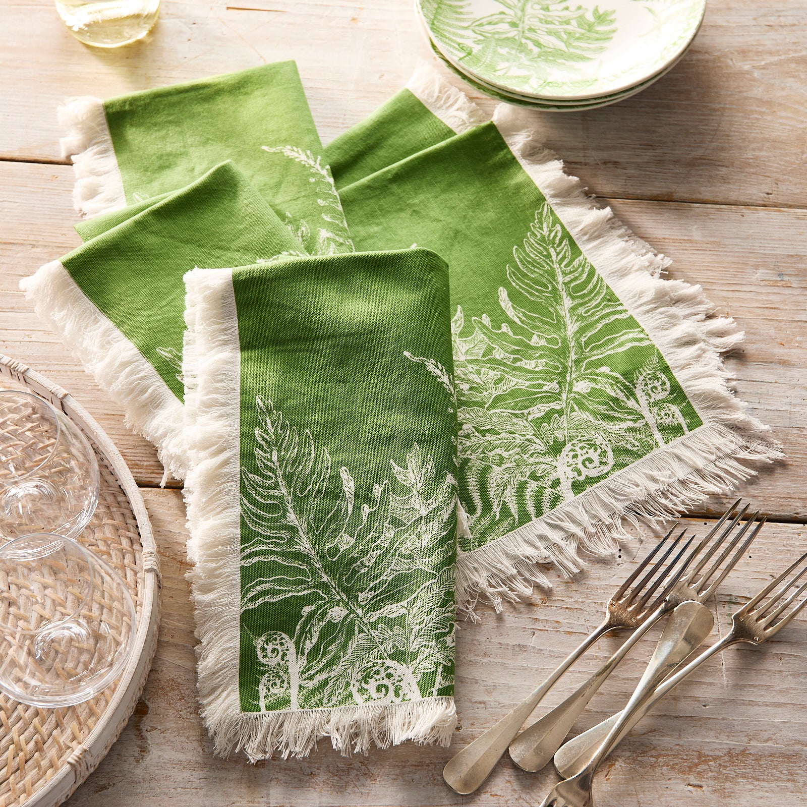 Caskata’s Spring Verde Dinner Napkins feature a set of four green cotton napkins with white fern leaf patterns and fringed ends, ideal for fresh spring table decor.