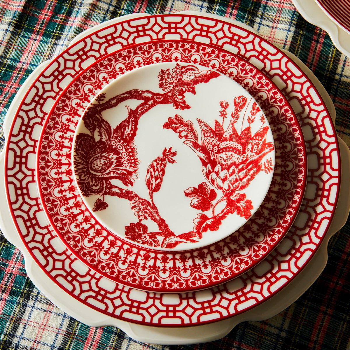 A Newport Garden Gate Crimson Dinner Plate by Caskata Artisanal Home on a table.