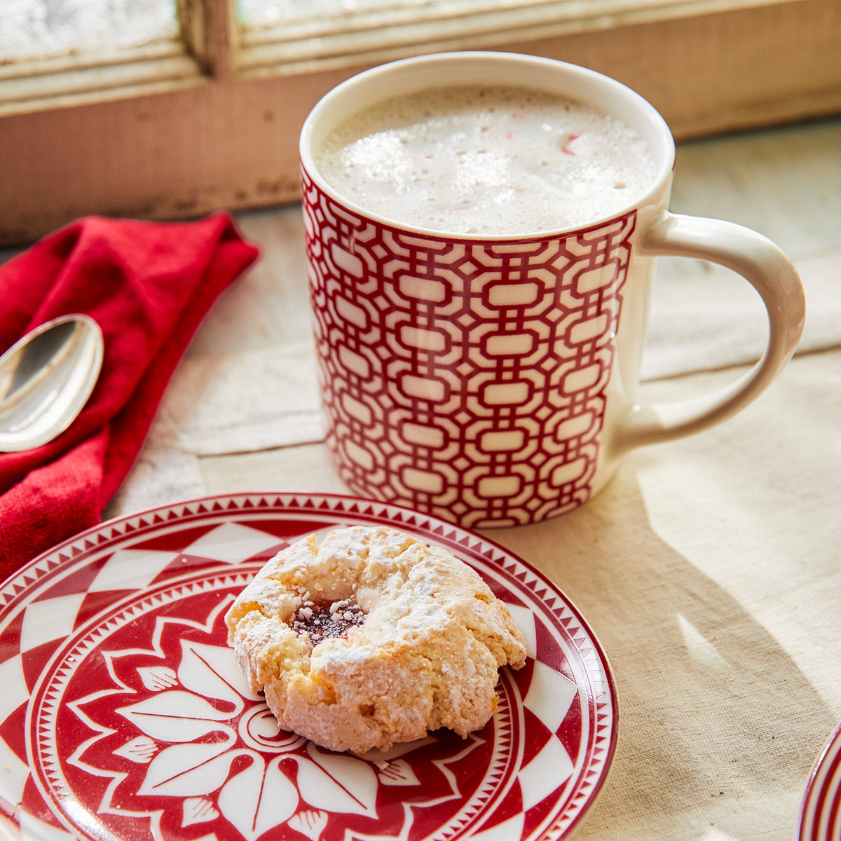 A Newport Garden Gate Crimson Mug of coffee and a donut on a Caskata Artisanal Home dinnerware plate.