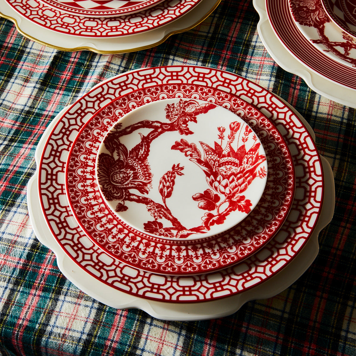 A polished Grace White Dinner Plate on a plaid tablecloth, exuding Caskata Artisanal Home.