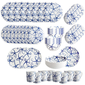 The Caskata Starfish Ultimate Set features white ceramic plates, bowls, mugs, and serving trays with coastal blue starfish designs, all arranged in rows on a white background.