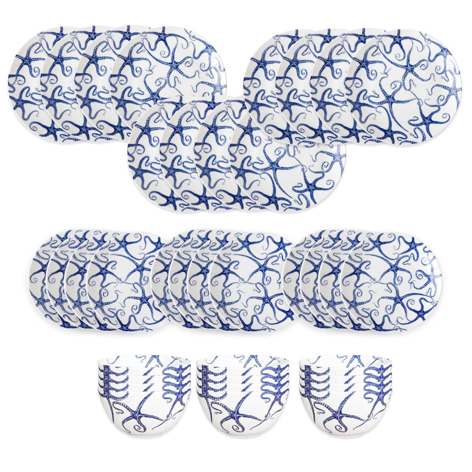 The Caskata Starfish Table for 12 set features oval and round white plates plus three bowls, all adorned with intricate blue swirled patterns like blue and white porcelain, arranged in rows on a white background.