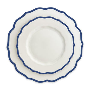 A set of three nested Caskata Stella Scalloped Blue Salad Plates, with white ceramic and blue edges, arranged from largest to smallest, echoing the vintage dinnerware style.