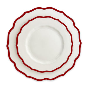 Two Caskata Stella Scalloped Crimson plates, one salad plate stacked on a larger plate, feature bold red trim and wavy edges, viewed from above on a white background.