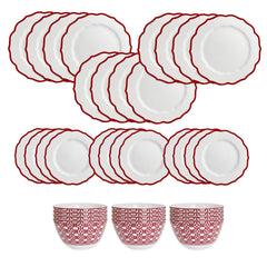 The Caskata Stella Red Table for 12 is a porcelain dinnerware set with twelve white plates featuring red scalloped edges and three white bowls with red geometric patterns—ideal holiday dinnerware.
