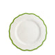 A Caskata Stella Scalloped Verde Salad Plate with a white ceramic body and a scalloped green rim evokes an heirloom feel, set against a plain white background.