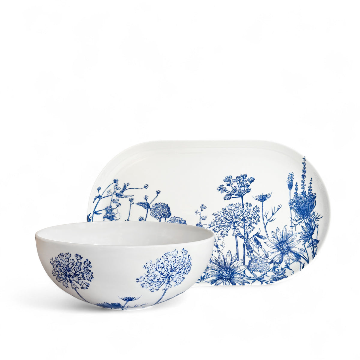 The Caskata Summer Blues Serving Set includes a white porcelain bowl and platter accented with intricate blue floral designs—a stylish dinnerware piece or perfect wedding gift.