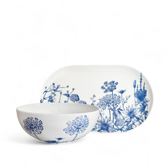 The Caskata Summer Blues Serving Set includes a white porcelain bowl and platter accented with intricate blue floral designs—a stylish dinnerware piece or perfect wedding gift.