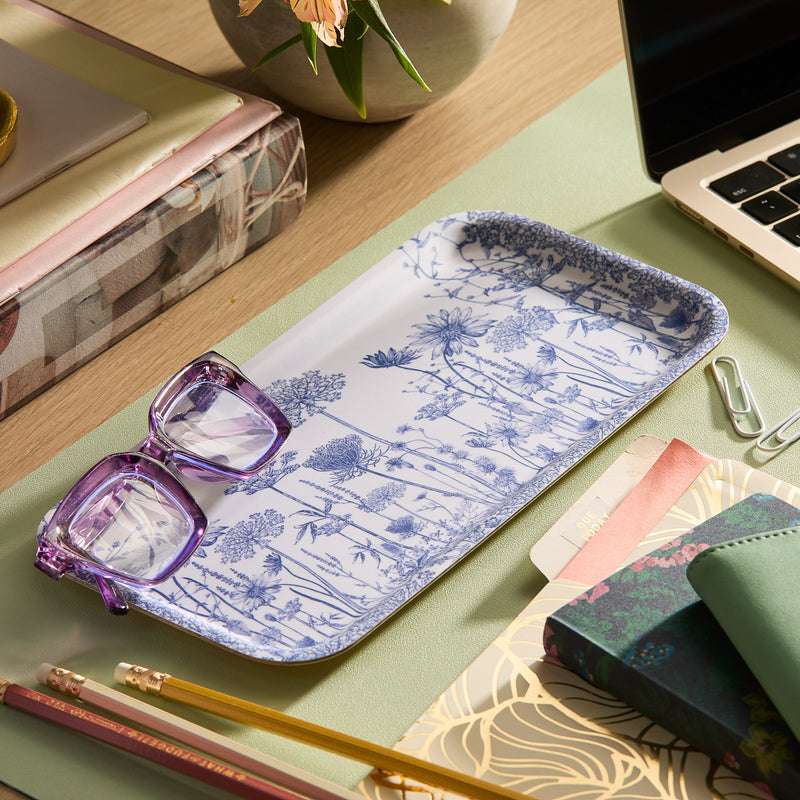 The Caskata "Blooming Blues" Bundle features a birchwood tray with a blue floral design and two purple glasses—an ideal cottage-core desk gift for organizing books, a laptop, pencils, and paperclips.