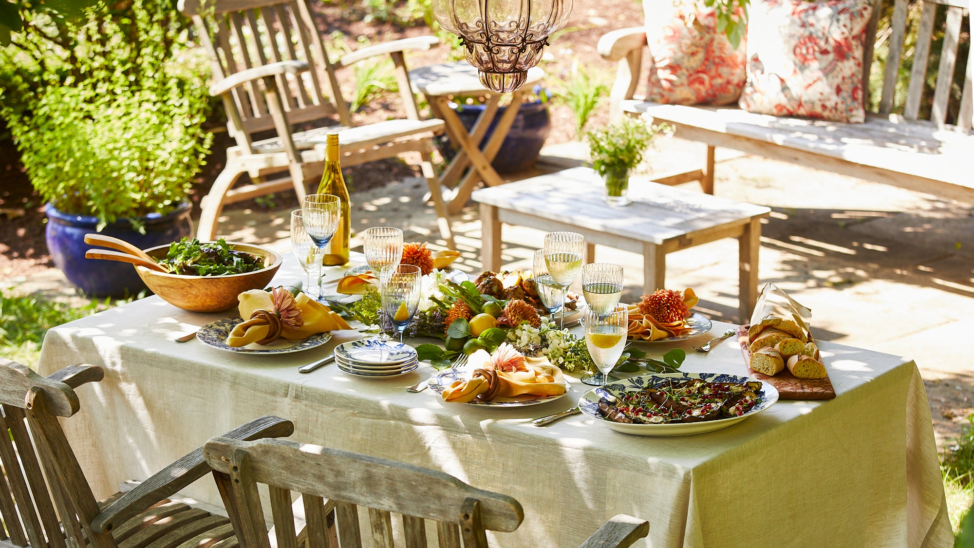 Outdoor entertaining with a beautiful table on a terrace set with Quinn glassware and porcelain dinnerware from Caskata