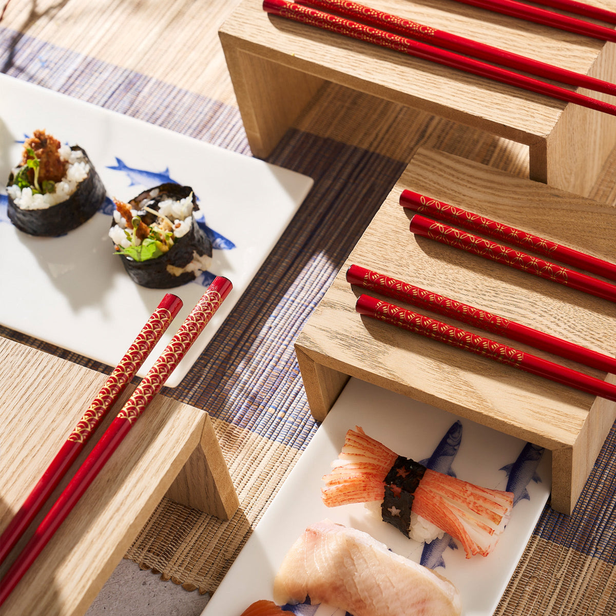 Japanese sushi and lacquered wood Tokyo Chopsticks with gold patterns on a wooden tray by Miya, Inc.