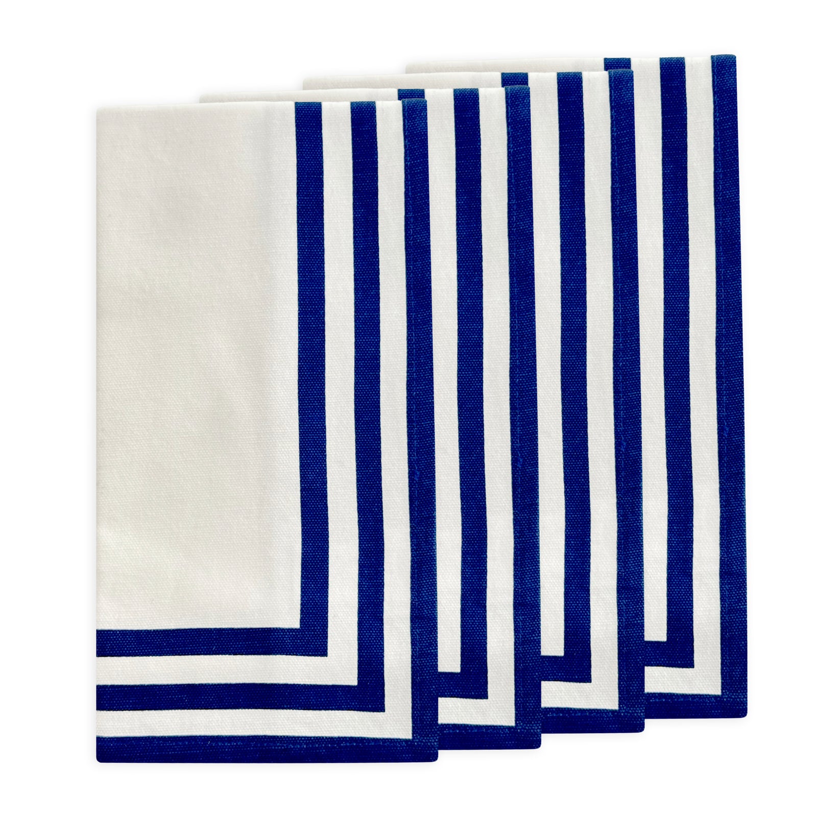 Caskata's Triple Stripe Blue Dinner Napkins come in a set of six white cotton napkins, each featuring three navy stripes along two edges. Machine washable, they offer classic style and easy care for everyday meals.