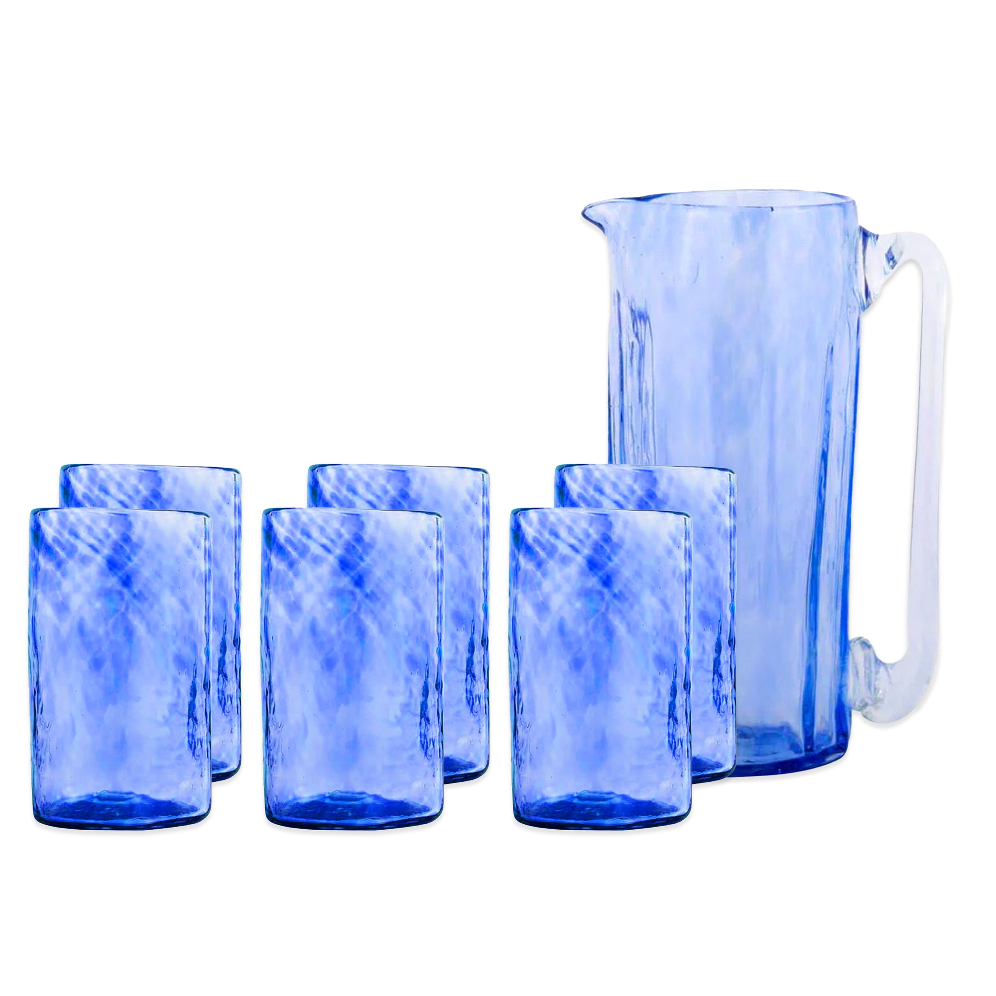 The "Feeling the Blues" Serving Bundle by Caskata features six cobalt blue glass tumblers and a matching handblown pitcher with handle—ideal for elevating your coastal bar cart.