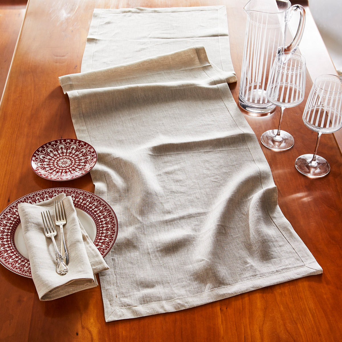 An Italian TTT wheat linen dinner napkins set/4 on a wooden table.