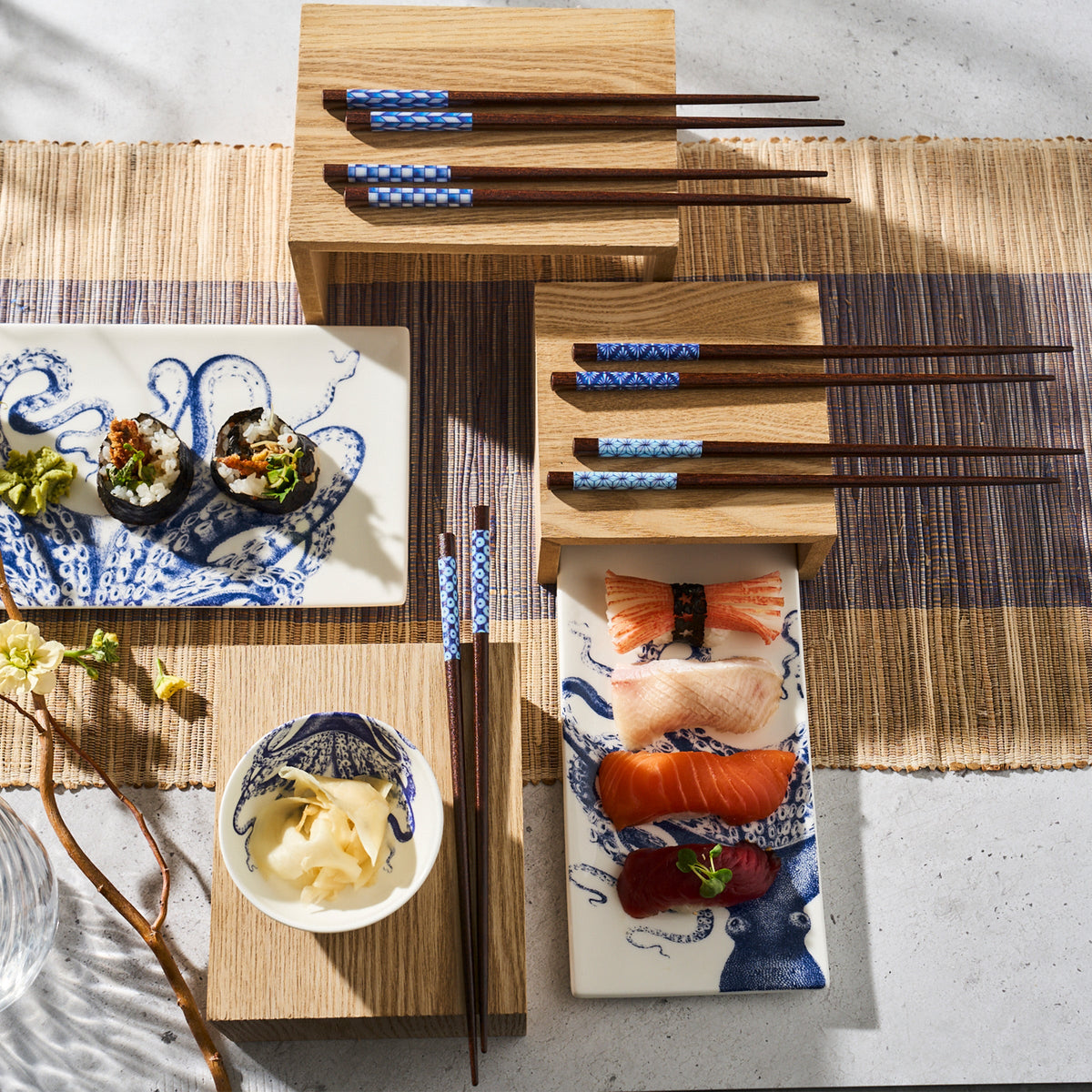 Yokohama Chopsticks and plates on a table, placed next to sushi trays. (Brand: Miya, Inc.)