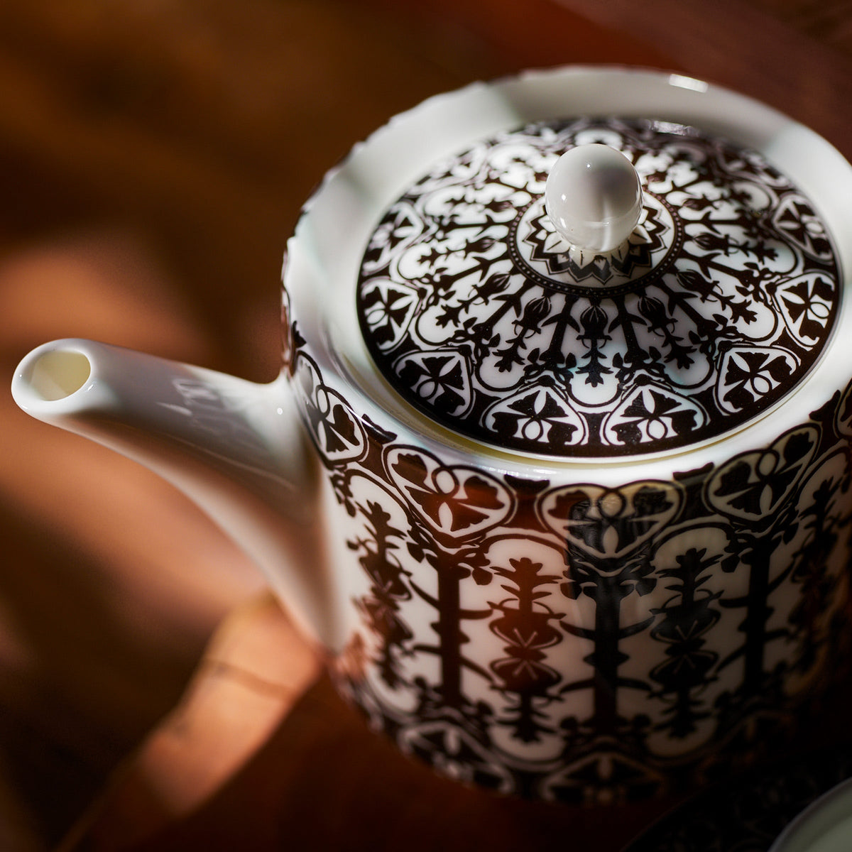 A Caskata Casablanca Petite Teapot, inspired by the classic film Casablanca, elegantly rests on a wooden table.