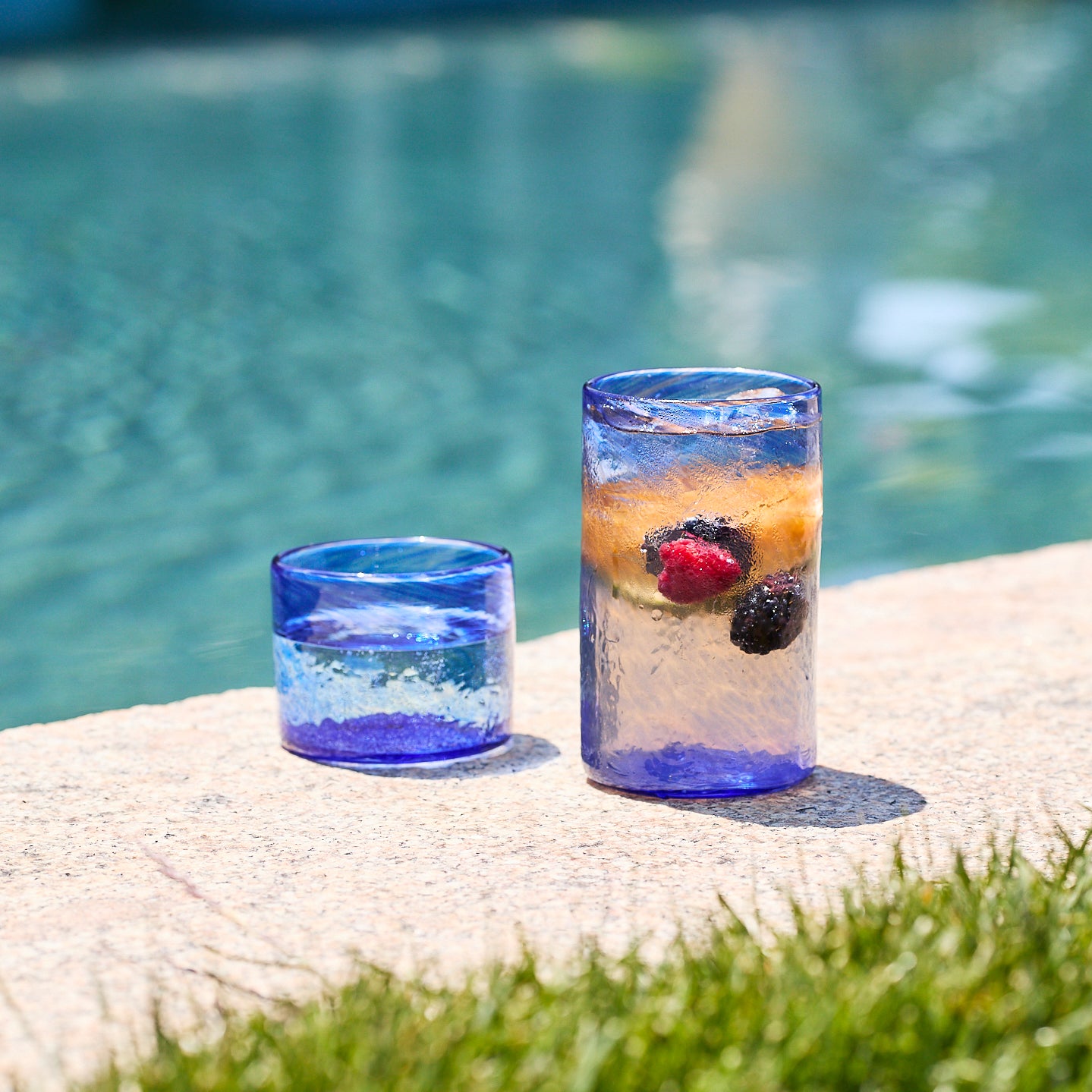 Six Caskata Viento Large Cobalt Tumblers, set of 6, crafted from recycled glass with a textured surface, are arranged in two rows on a white background.
