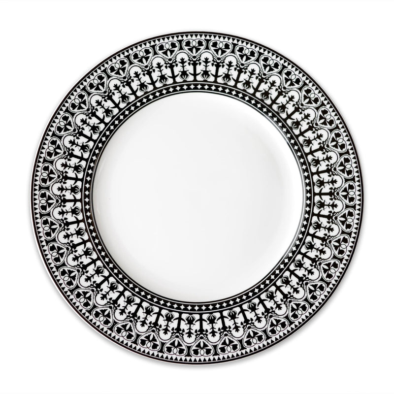 A Casablanca Rimmed Dinner Plate from Caskata Artisanal Home, featuring an intricate black floral pattern around the rim and hand-decorated details.