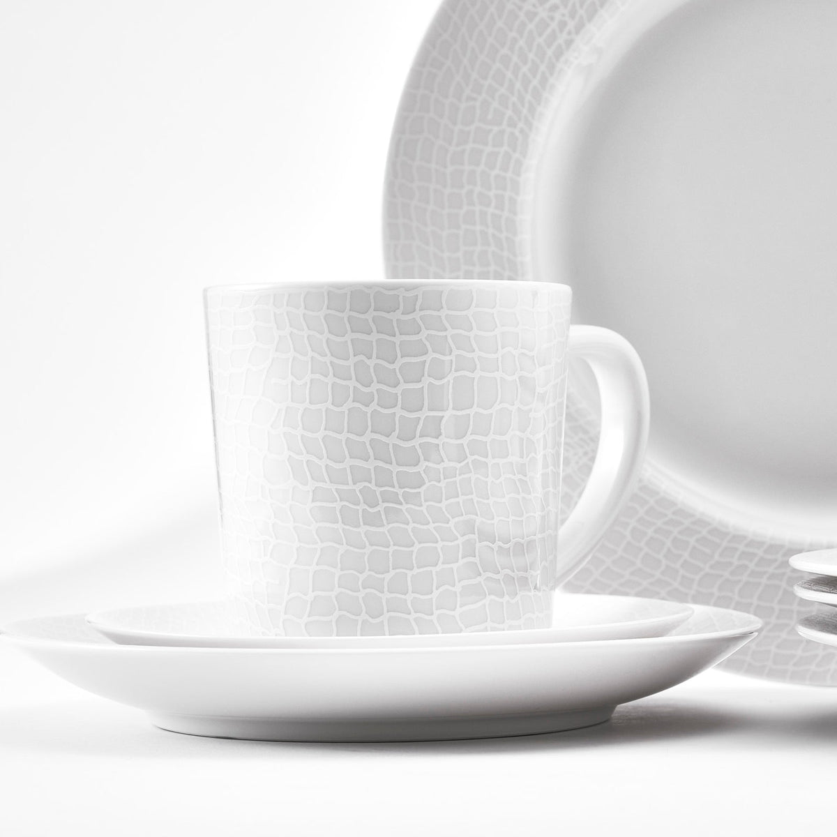 Closeup of mug in 16 piece dinnerware set from Caskata in Catch pattern based on a fisherman&#39;s net