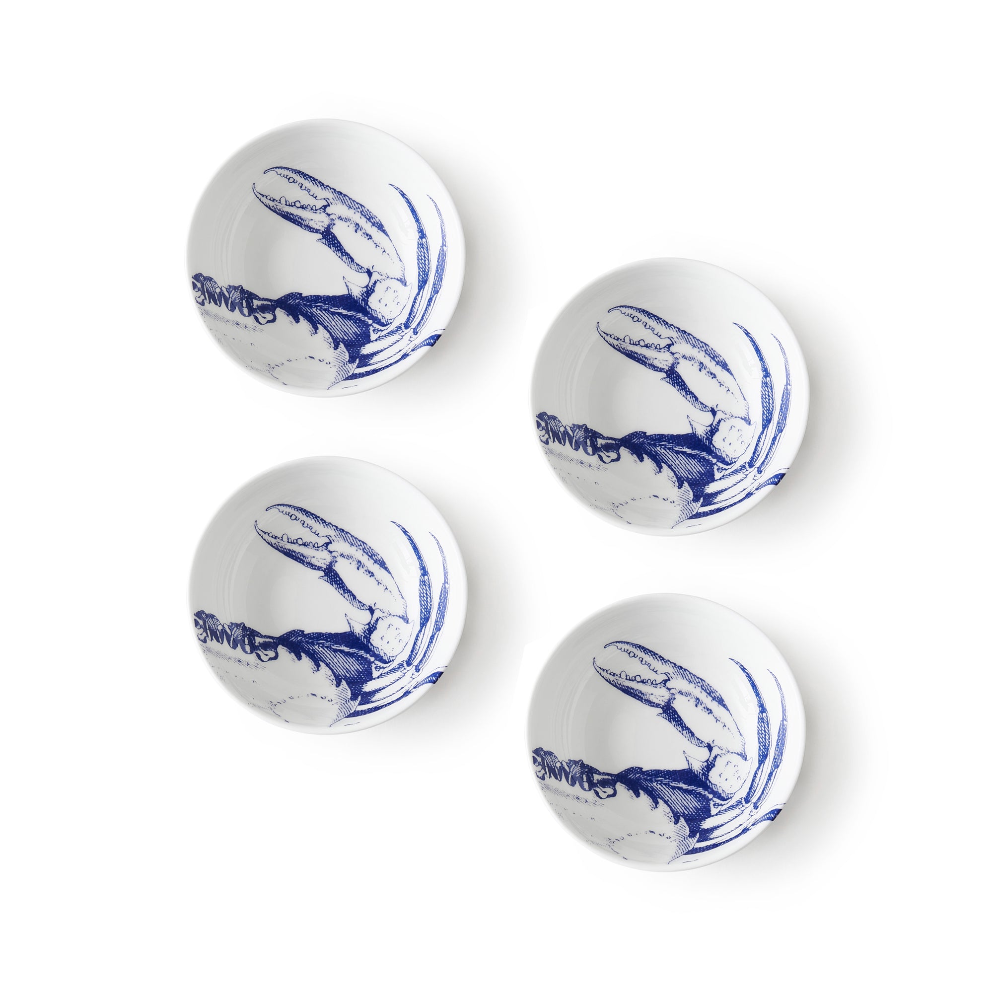 Four white bone china bowls with blue crab pattern illustrations placed in a grid pattern on a white background, perfect for serving sauces—Crab Dipping Dishes, Set of 4 by Caskata.