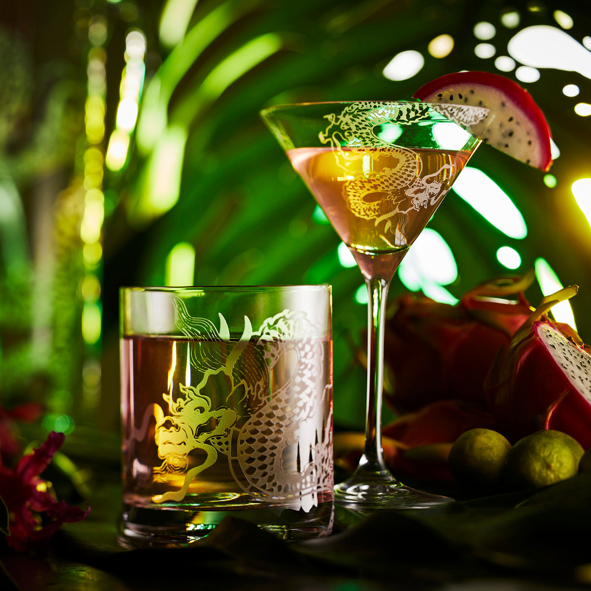 Dragon etched crystal martini glass and Double Old Fashion tumbler glass in a tropical setting with passionfruit cocktails from Caskata