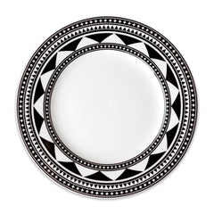 A Fez Rimmed Dinner Plate by Caskata Artisanal Home, a white plate with a wide rim, showcasing a black and white geometric pattern reminiscent of Moroccan designs.