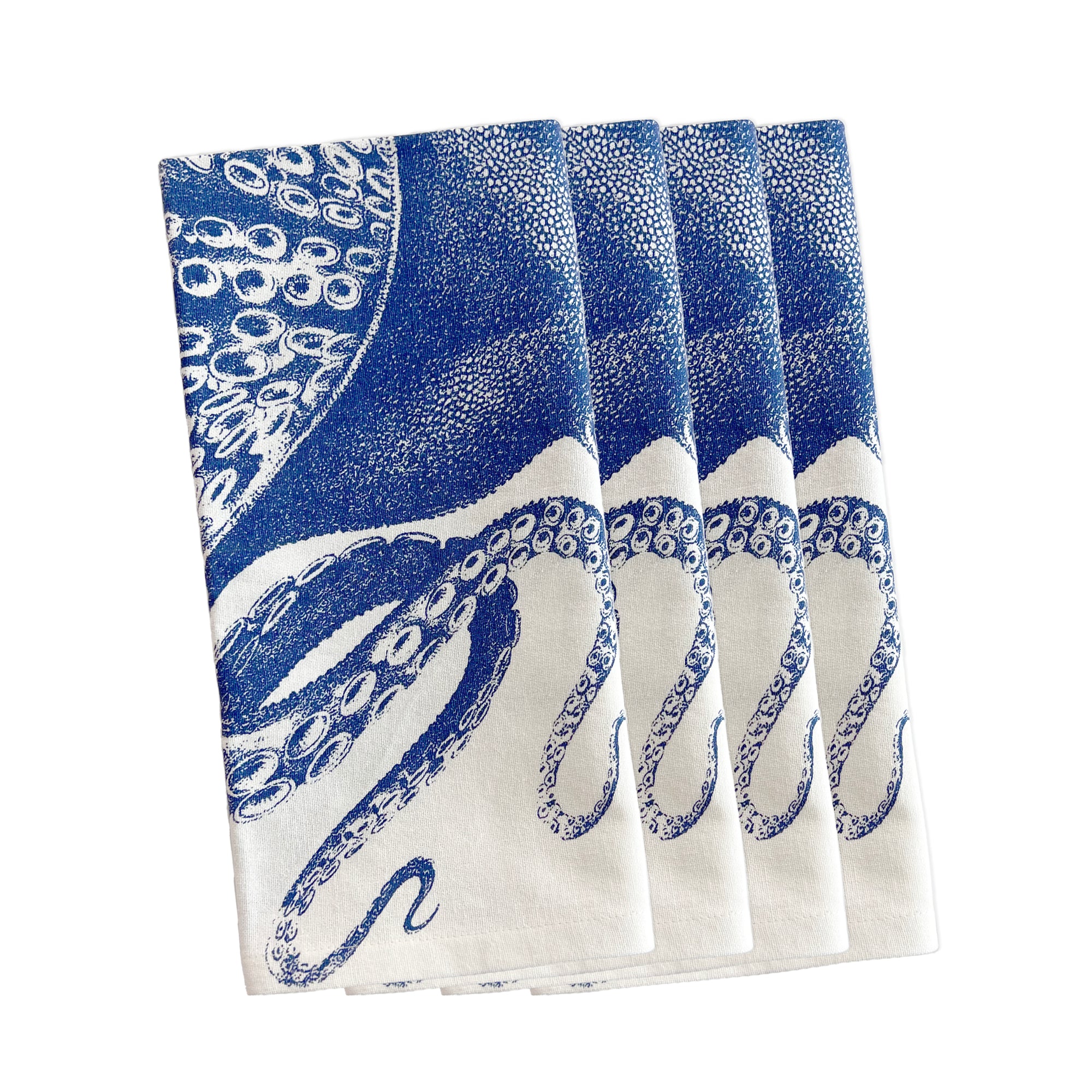 Four folded Caskata Lucy Dinner Napkins, Set of 4, with a blue octopus illustration printed on them, seamlessly blending into your blue and white table linens.
