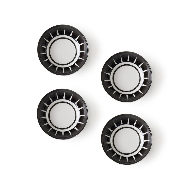 Four black and white plates, designed in a Moroccan-inspired pattern, are arranged in a grid on a plain white background. Each plate features circular designs with radial stripes. These are the Marrakech Dipping Dishes, Set of 4 by Caskata.