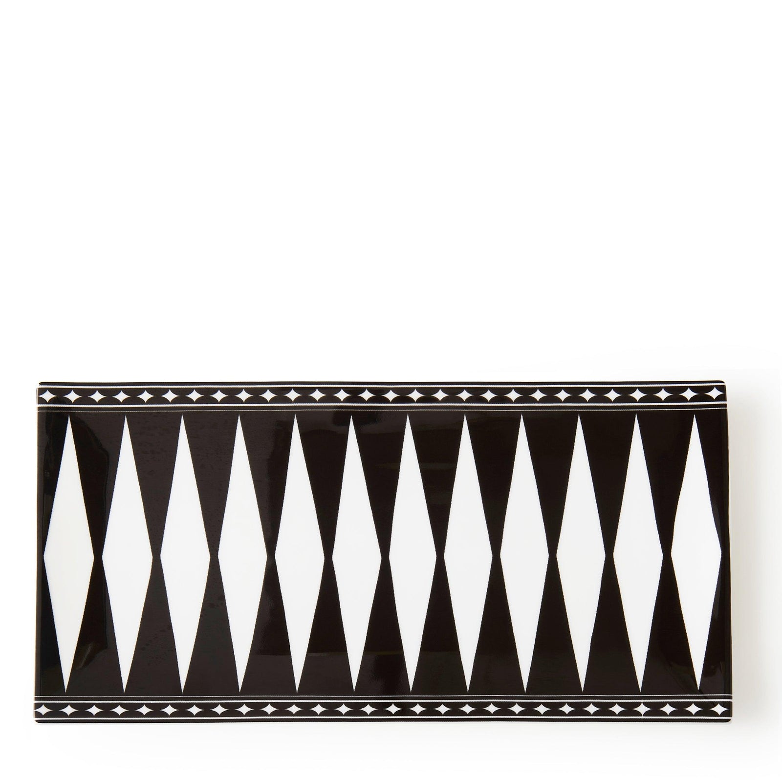 The Marrakech Petite Serving Tray by Caskata is a rectangular ceramic platter featuring a black and white geometric harlequin pattern, reminiscent of vibrant Art Deco style.
