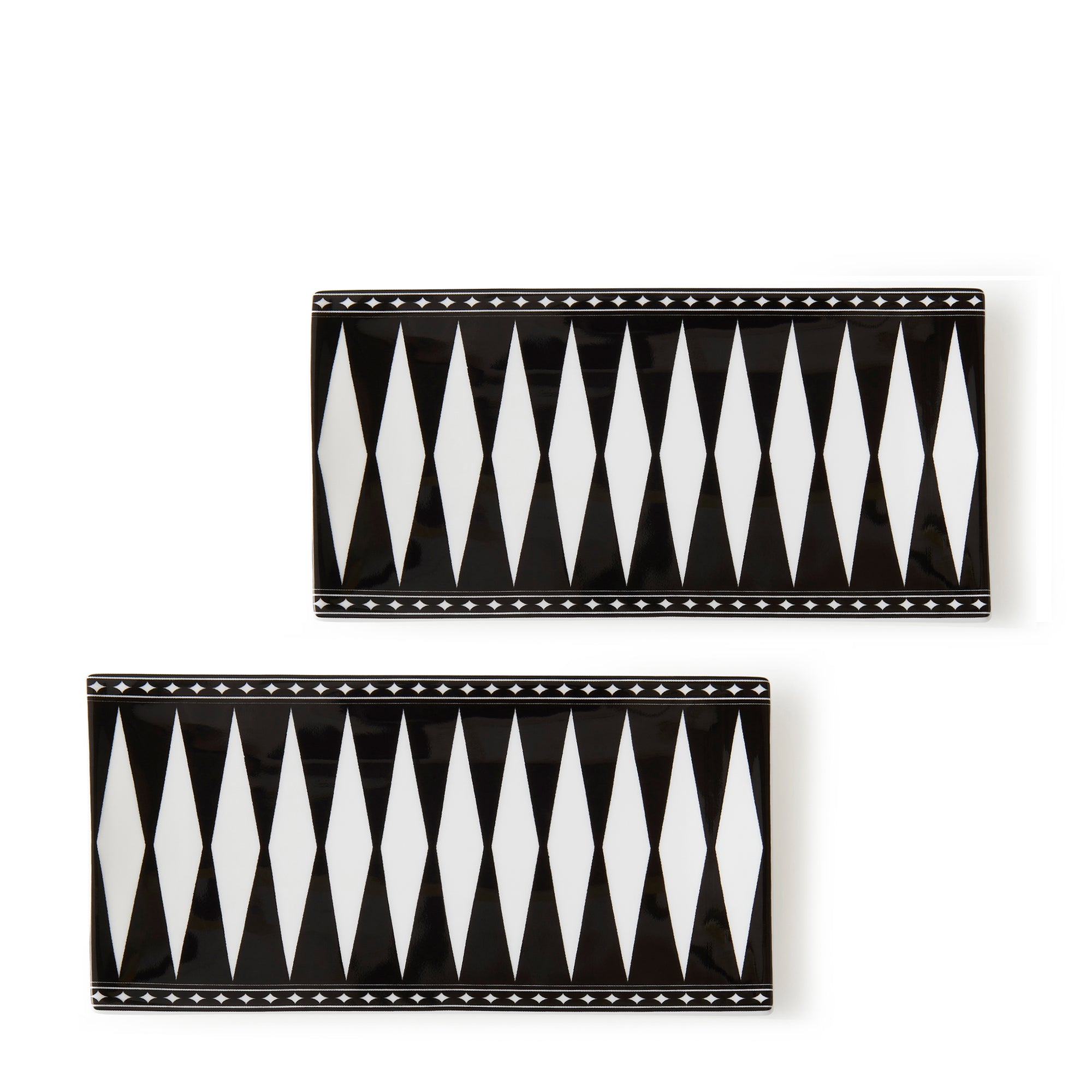 Two rectangular bone china plates feature black and white geometric diamond patterns with star accents along the borders, evoking an Art Deco elegance reminiscent of Caskata's Marrakech Medium Sushi Trays, Set of 2.