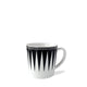 The Marrakech Mug by Caskata Artisanal Home is a white high-fired porcelain coffee mug with a black geometric triangular pattern and a black border adorned with small white stars near the rim, reminiscent of Art Deco designs.